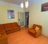 NA PREDAJ 5 izbový rodinný dom s veľkou záhradou v obci Iža - Obývacia izba v rodinnom dome s oranžovým nábytkom a podlahou s dreveným dekorom.