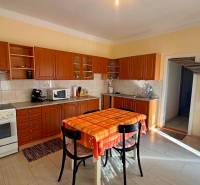 NA PREDAJ 5 izbový rodinný dom s veľkou záhradou v obci Iža - Kuchyňa v rodinnom dome s dreveným dekórom a jedálenským stolom.