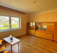 NA PREDAJ 5 izbový rodinný dom s veľkou záhradou v obci Iža - Obývačka v rodinnom dome s nábytkom a podlahou s dreveným dekorom.