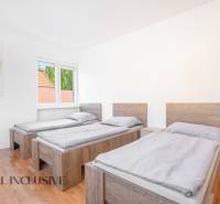 Na predaj 7-izb. RD s obchod. priestorom, Dun. Streda - Tri postele v izbe s podlahou s dreveným dekorom a obrazom na stene.