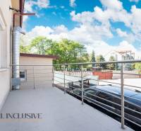 Na predaj 7-izb. RD s obchod. priestorom, Dun. Streda - Balkón budovy v Dunajskej Strede s kovovým zábradlím a pohľadom na okolie.