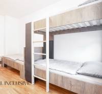 Na predaj 7-izb. RD s obchod. priestorom, Dun. Streda - Interiér s poschodovou posteľou a podlahou s dreveným dekorom v budove.