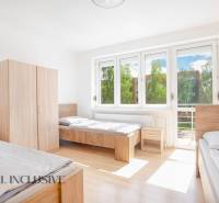 Na predaj 7-izb. RD s obchod. priestorom, Dun. Streda - Svetlá izba s tromi posteľami, bielymi stenami, skriňami a veľkými oknami.