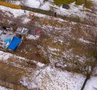 Nálepkovo – 99 m2 STAVEBNÝ pozemok v obci - Záhrady v Nálepkove so zaľadneným snehom, staršími prístreškami a oploteniami v zime.