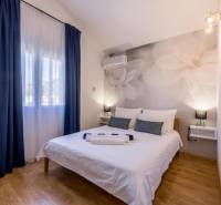 Kaštela(HR)-moderná vila s krásnym výhľadom - Spálňa vo Vile s veľkými kvetmi na stene a podlahou s dreveným dekorom.