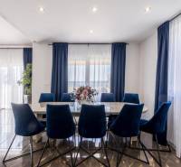 Kaštela(HR)-moderná vila s krásnym výhľadom - Jedáleň vo Vile s tmavými závesmi, podlahou s dreveným dekorom a modrými stoličkami.