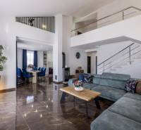 Kaštela(HR)-moderná vila s krásnym výhľadom - Obývačka vile s pohodlnou sedačkou, jedálňou a schodiskom, podlaha s dreveným dekorom.