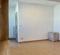 I Predaj Investičného 1-izbového bytu s veľkorysou loggiou  - Biely interiér 1-izbového bytu s dlažbou a dreveným dekorom.