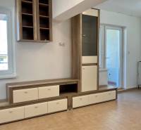 I Predaj Investičného 1-izbového bytu s veľkorysou loggiou  - Obývací priestor v 1-izbovom byte s nábytkom a keramickou podlahou.