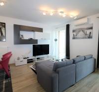 NUERA︱ SLNEČNICE- slnečný 2izbový byt s výhľadom na hrad - Obývacia izba v 2-izbovom byte s pohovkou, TV, podlahou s dreveným dekorom.