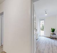 PREDAJ - 4-izb. byt na Sklenárovej ul., 67 m2, komplet. rekonštrukcia - Interiér 4-izbového bytu s bielymi stenami a podlahou s dreveným dekorom.