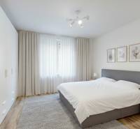 PREDAJ - 4-izb. byt na Sklenárovej ul., 67 m2, komplet. rekonštrukcia - Spálňa v 4-izbovom byte s veľkou posteľou, šatníkovou skriňou a bielymi závesmi.