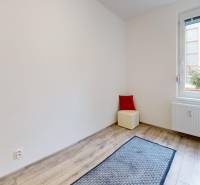 PREDAJ - 4-izb. byt na Sklenárovej ul., 67 m2, komplet. rekonštrukcia - Izba v 4-izbovom byte s podlahou s dreveným dekorom, oknom a radiátorom.