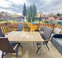Predám peknú chatu na celoročné bývanie v Nových zámkoch - Na terase chaty v Nových Zámkoch sa nachádza stôl s kreslami a pohovkou.