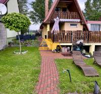 Predám peknú chatu na celoročné bývanie v Nových zámkoch - Chata v obci Nové Zámky s červenou strechou, terasou a záhradou na oddych.