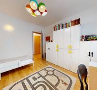 Na predaj moderný 3i byt v novostavbe Ovocné sady s parkovaním, BA - Detská izba v 3-izbovom byte s množstvom hračiek a podlahou s dreveným dekorom.