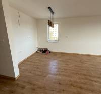 Na predaj 2 izbový byt GEENSIDE Trebišov - Izba 2-izbového bytu s podlahou s dreveným dekorom a závesnými svietidlami.