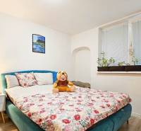 Rodinný dom v obci Bernolákovo, po kompletnej rekonštrukcii - Spálňa v rodinnom dome s kvetinovým vzorom postele a dekoráciami.