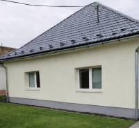 Rodinný dom v obci Bernolákovo, po kompletnej rekonštrukcii - Rodinný dom v Bernolákove s trávnikom, šedou strechou a svetlou fasádou.