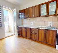 Predaj, trojizbový byt v Kremnici - Kuchyňa v 3-izbovom byte s linkou, spotrebičmi a podlahou s dreveným dekorom.