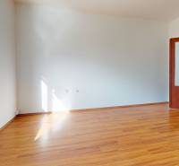 Predaj, trojizbový byt v Kremnici - Izba v 3-izbovom byte s podlahou s dreveným dekorom a svetlými stenami.