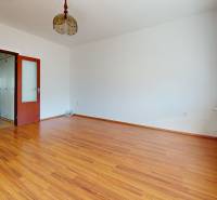 Predaj, trojizbový byt v Kremnici - Izba v 3-izbovom byte s podlahou s dreveným dekorom a veľkým oknom.