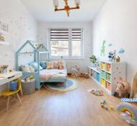 Predaj, trojizbový byt v Kremnici - Detská izba v 3-izbovom byte s podlahou s dreveným dekorom a hravým dekorom.