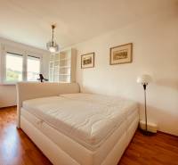 EXKLUZÍVNE! | Krásny 2-izbový byt | 52m² | Považanova - Svetlá spálňa v 2-izbovom byte s podlahou s dreveným dekorom a veľkým oknom.