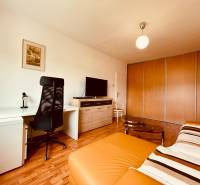 EXKLUZÍVNE! | Krásny 2-izbový byt | 52m² | Považanova - Izba v 2-izbovom byte s podlahou s dreveným dekorom, písacím stolom a sedačkou.