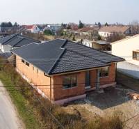 PRIESTRANNÁ 4-IZBOVÁ NOVOSTAVBA 167.38m²- BUNGALOV NA POZEMKU AŽ 702m² - Rodinný dom v Pavliciach vo fáze výstavby so šikmou strechou a tehlovou fasádou.