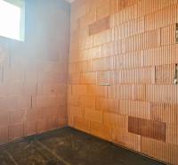 PRIESTRANNÁ 4-IZBOVÁ NOVOSTAVBA 167.38m²- BUNGALOV NA POZEMKU AŽ 702m² - Stena z tehál a podlaha s dreveným dekorom v rodinnom dome.