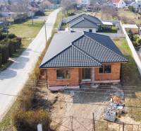 PRIESTRANNÁ 4-IZBOVÁ NOVOSTAVBA 167.38m²- BUNGALOV NA POZEMKU AŽ 702m² - Rodinný dom v Pavliciach so strechou z čiernych škridiel na trávnatom pozemku.