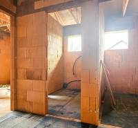 PRIESTRANNÁ 4-IZBOVÁ NOVOSTAVBA 167.38m²- BUNGALOV NA POZEMKU AŽ 702m² - Interiér rozostavaného rodinného domu s tehlovými priečkami a strešnými nosníkmi.