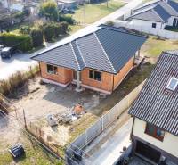 PRIESTRANNÁ 4-IZBOVÁ NOVOSTAVBA 167.38m²- BUNGALOV NA POZEMKU AŽ 702m² - Rodinný dom v Pavliciach, súčasť obytnej štvrti, s plechovou strechou a nedokončeným okolím.
