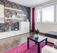 4-i., zariadený, lodžia, pivnica, internet, Röntgenova ul. - Obývačka v 4-izbovom byte s výraznou tapetou, podlahou s dreveným dekorom a fialovými detailmi.