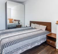 4-i., zariadený, lodžia, pivnica, internet, Röntgenova ul. - Spálňa s podlahou s dreveným dekorom a vstavanou skriňou v 4-izbovom byte.