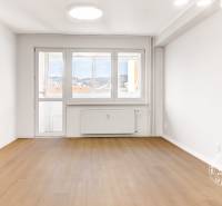 Nezariadený 3i byt po komp. rek. s lodžiou, Budyšínska - Svetlá obývacia izba s podlahou s dreveným dekorom v 3-izbovom byte.