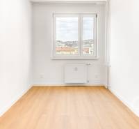 Nezariadený 3i byt po komp. rek. s lodžiou, Budyšínska - Izba v 3-izbovom byte s podlahou s dreveným dekorom a výhľadom z okna.