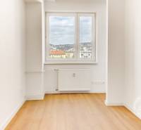 Nezariadený 3i byt po komp. rek. s lodžiou, Budyšínska - Izba v 3-izbovom byte s podlahou s dreveným dekorom a výhľadom z okna.