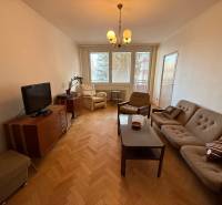 Ponúkame na prenájom priestranný 3-izbový byt v centre Martina  - Obývacia izba v 3-izbovom byte s pohovkou, televízorom a podlahou s dreveným dekorom.