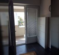 NIN-GRBLJANSKE VIKENDICE - dom s dvoma bytmi - Vstup na balkón v rodinnom dome s kachľovou podlahou a bielym nábytkom.