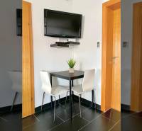 NIN-GRBLJANSKE VIKENDICE - dom s dvoma bytmi - Jedáleň v rodinnom dome s rohovým stolom, televízorom na stene a čiernymi dlaždicami.