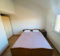 NIN-GRBLJANSKE VIKENDICE - dom s dvoma bytmi - Spálňa v rodinnom dome s posteľou, nočným stolíkom a podlahou s dreveným dekorom.