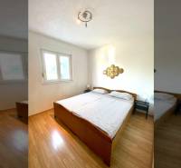 NIN-GRBLJANSKE VIKENDICE - dom s dvoma bytmi - Spálňa v rodinnom dome s dvojlôžkom a podlahou s dreveným dekorom.