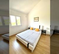 NIN-GRBLJANSKE VIKENDICE - dom s dvoma bytmi - Spálňa v rodinnom dome s podlahou s dreveným dekorom, posteľou a oknom.