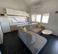 NIN-GRBLJANSKE VIKENDICE - dom s dvoma bytmi - Kuchyňa s rohovým gaučom a jedálenským stolíkom, rodinný dom, podlaha s tmavým obkladom.