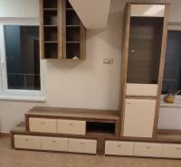 1-izb. byt, Krížná ul., Staré Mesto s veľkou lodžiou - Obývacia izba v 1-izbovom byte s nábytkom, oknom a podlahou s dreveným dekorom.