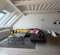 4 Izbový byt na Medenej ulici na prenájom - Obývacia izba s podlahou s dreveným dekorom, pohovkou a jedálenským stolom v 4-izbovom byte.