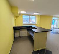 Obchodný priestor v Nitre s parkovaním - Svetlé obchodné priestory s pultom a dlažbou na podlahe.