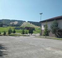 SKI MAKOV, 1 izbový byt - Apartmán 46 m2 - Lyžiarsky svah v Makove s priľahlou budovou a zeleňou v okolí.